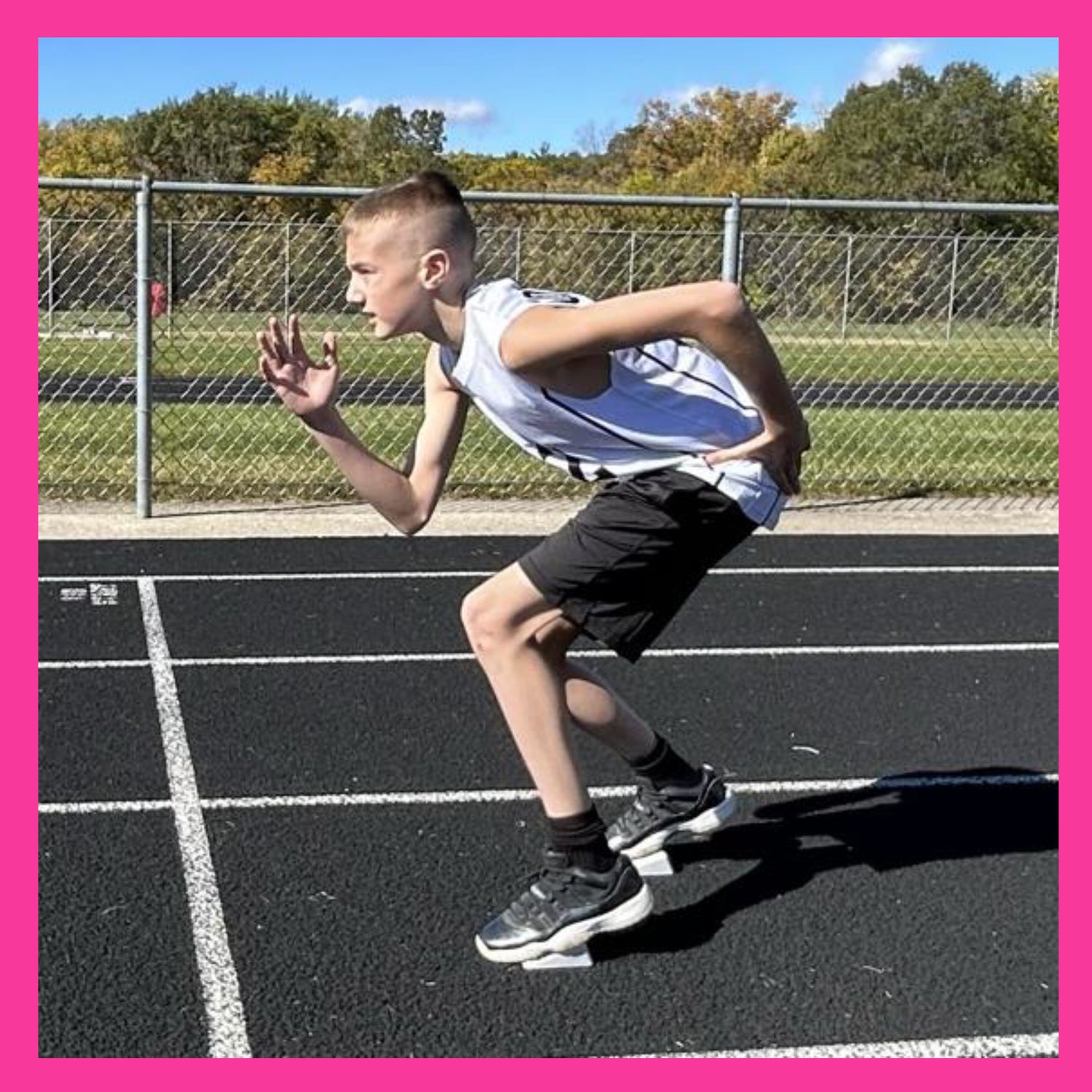 male youth track runner at the starting line in a 2 point stance