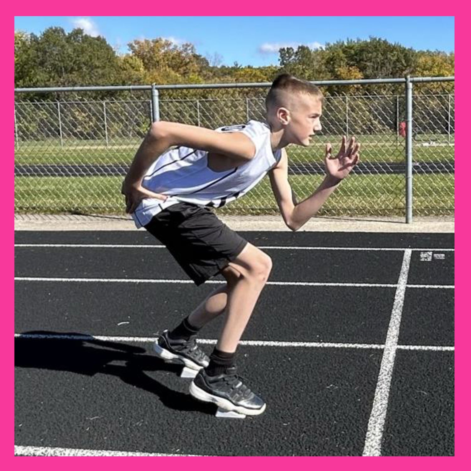 male youth track runner at the starting line in a 2 point stance