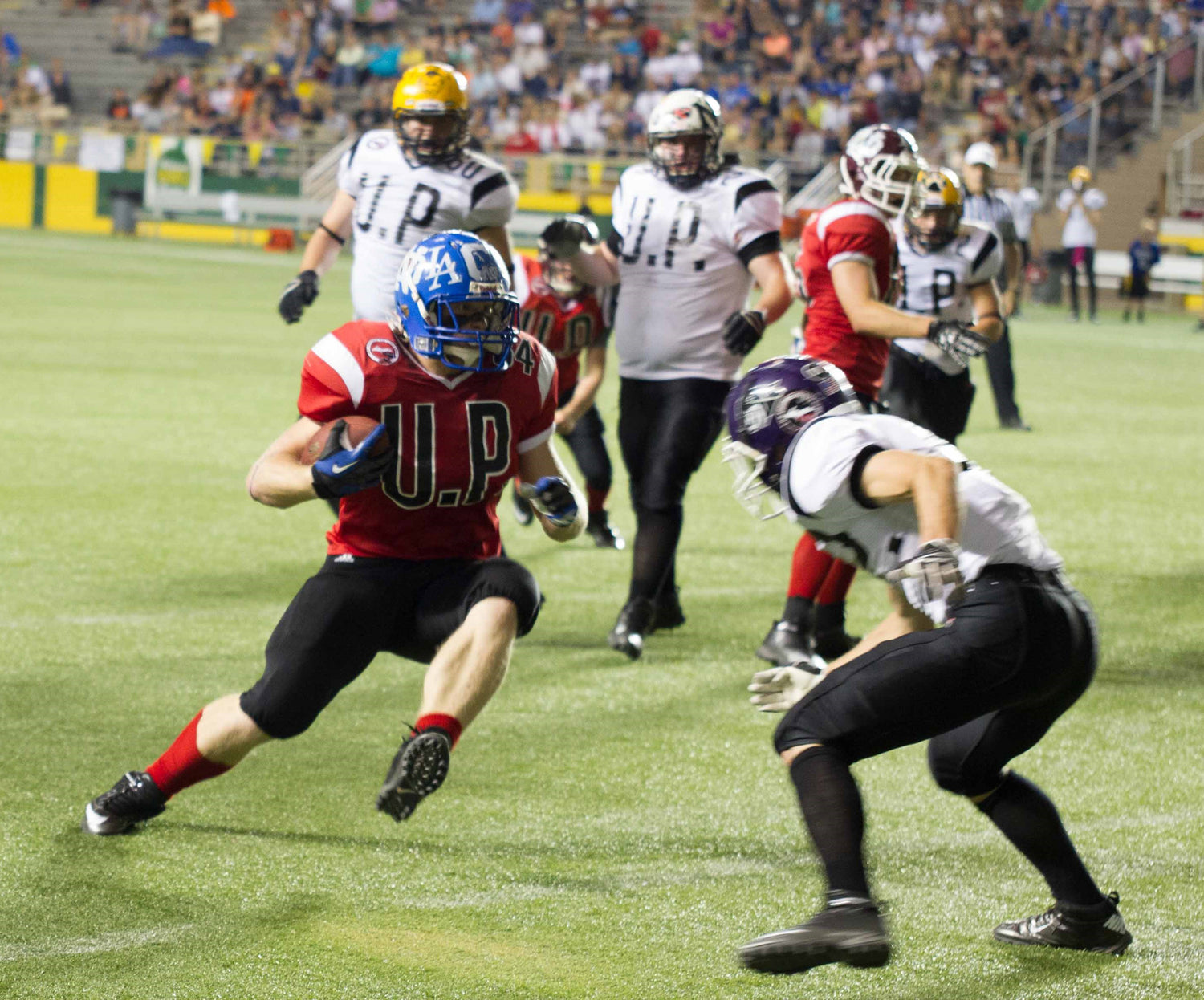 football player running with the ball while the defender attempts to stop a touchdown